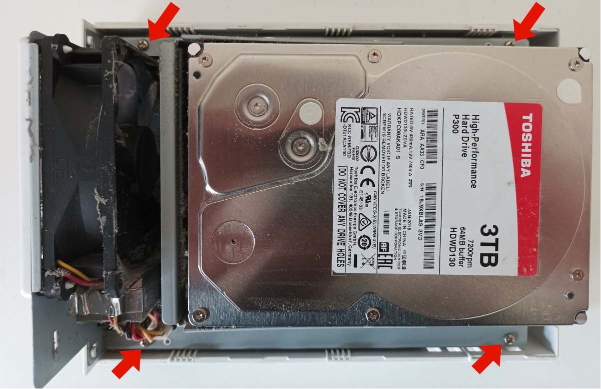 Interior view of a a Synology DS215j NAS showing the hard disks and internal screws are highlighted with arrows.